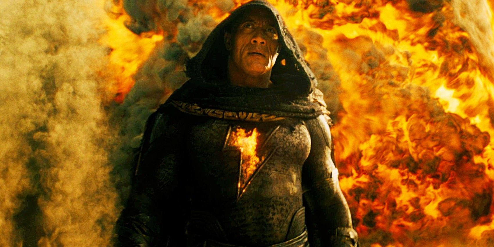 Dwayne Johnson as Black Adam walking front of a wall of fire