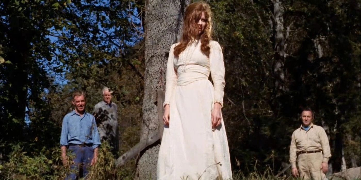 Emily standing in a white dress with people staring at her in Let's Scare Jessica To Death