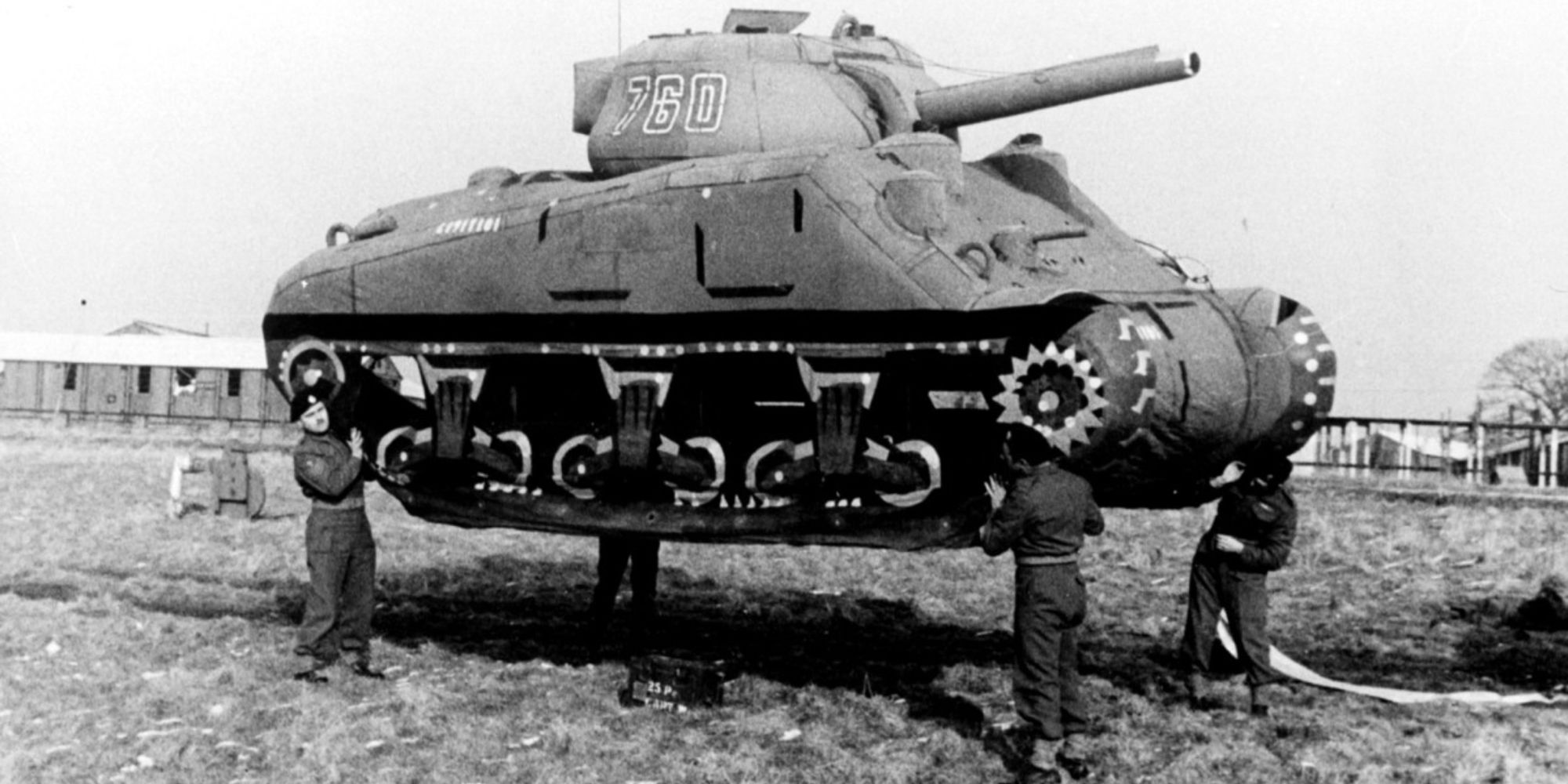 Allied soldiers lift up a dummy tank