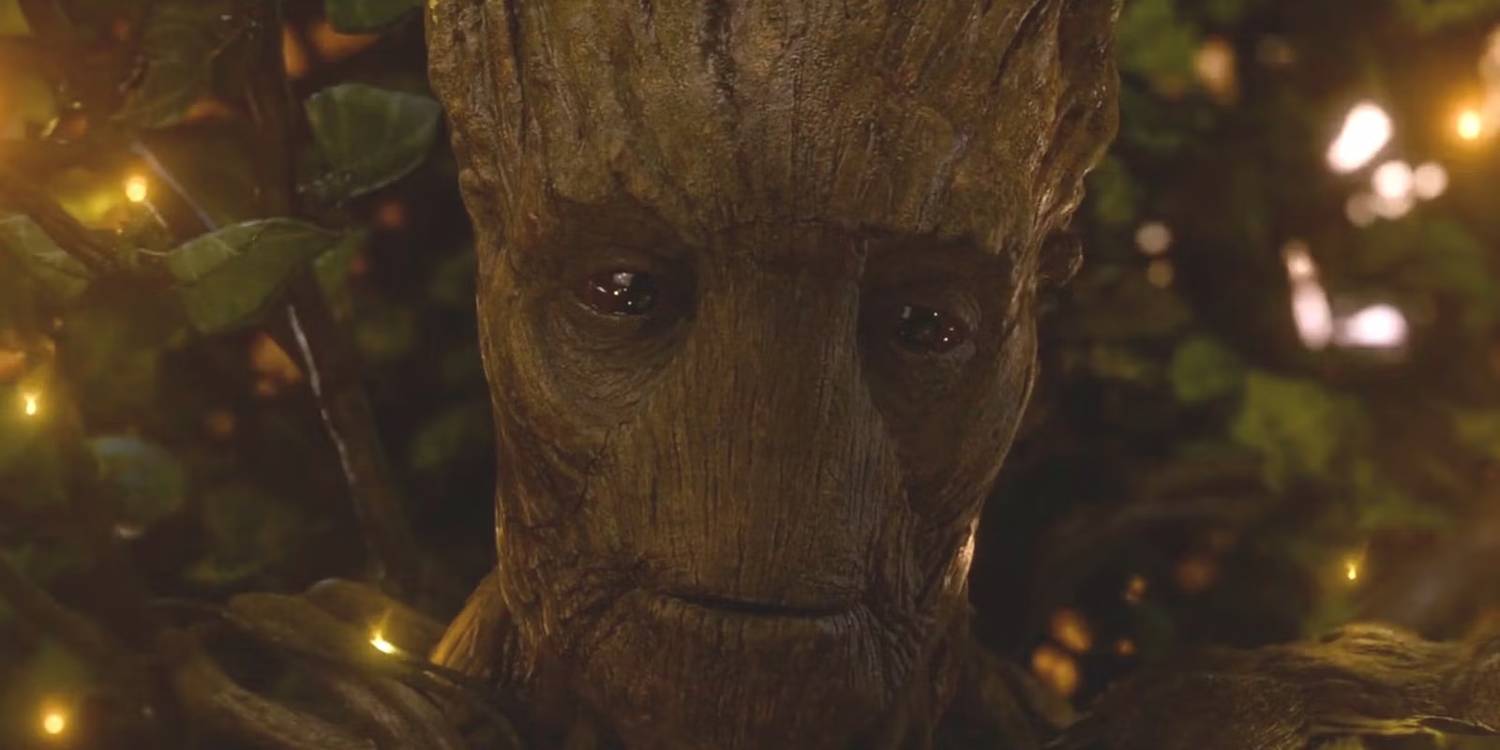 Groot sorri enquanto flashes de luz brilham ao seu redor em Guardiões da Galáxia