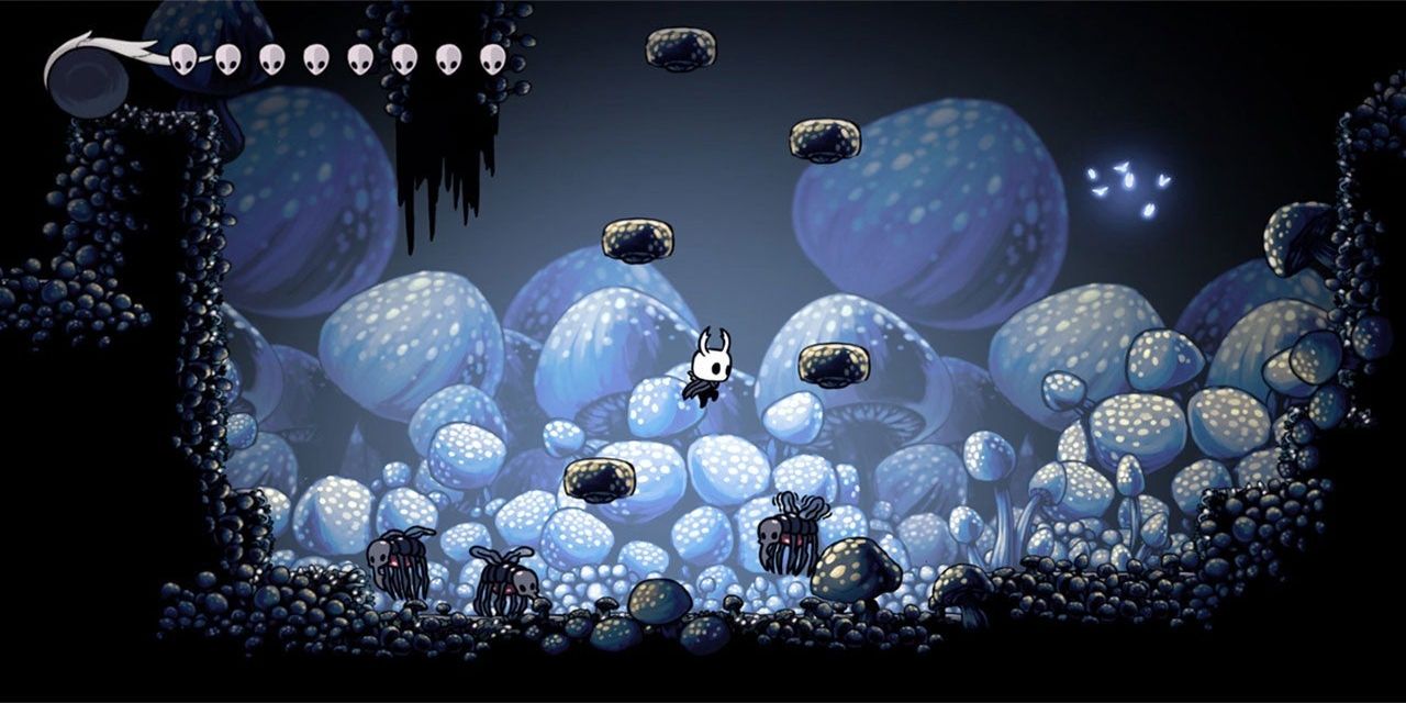The Knight jumps from platform to platform in the game Hollow Knight.