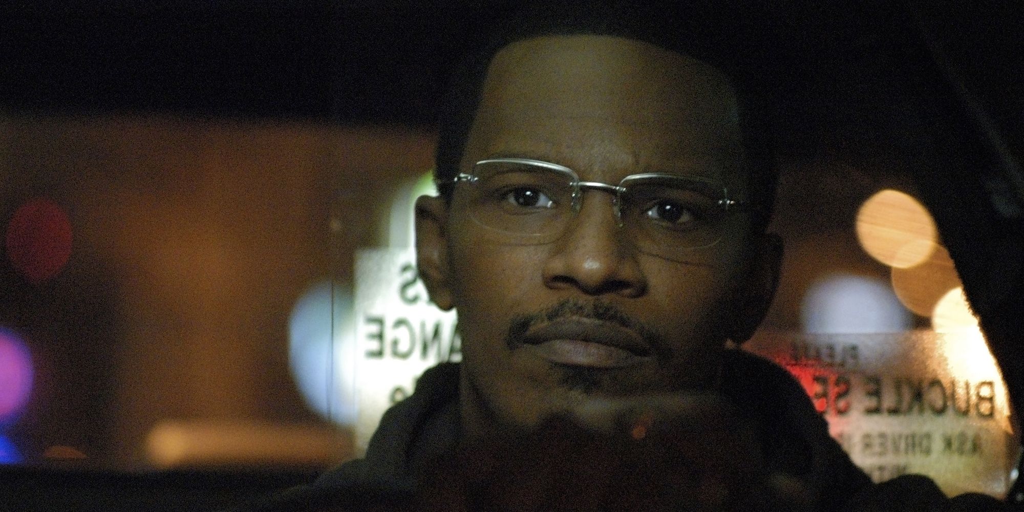 Jamie Foxx looks remorseful as he drives a taxi cab in Collateral