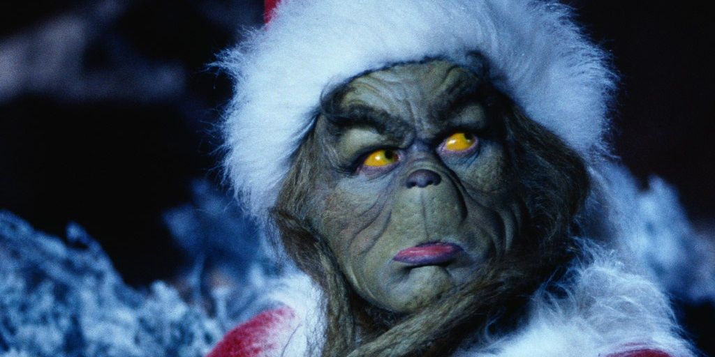 Jim Carrey as the Grinch wearing a Santa costume