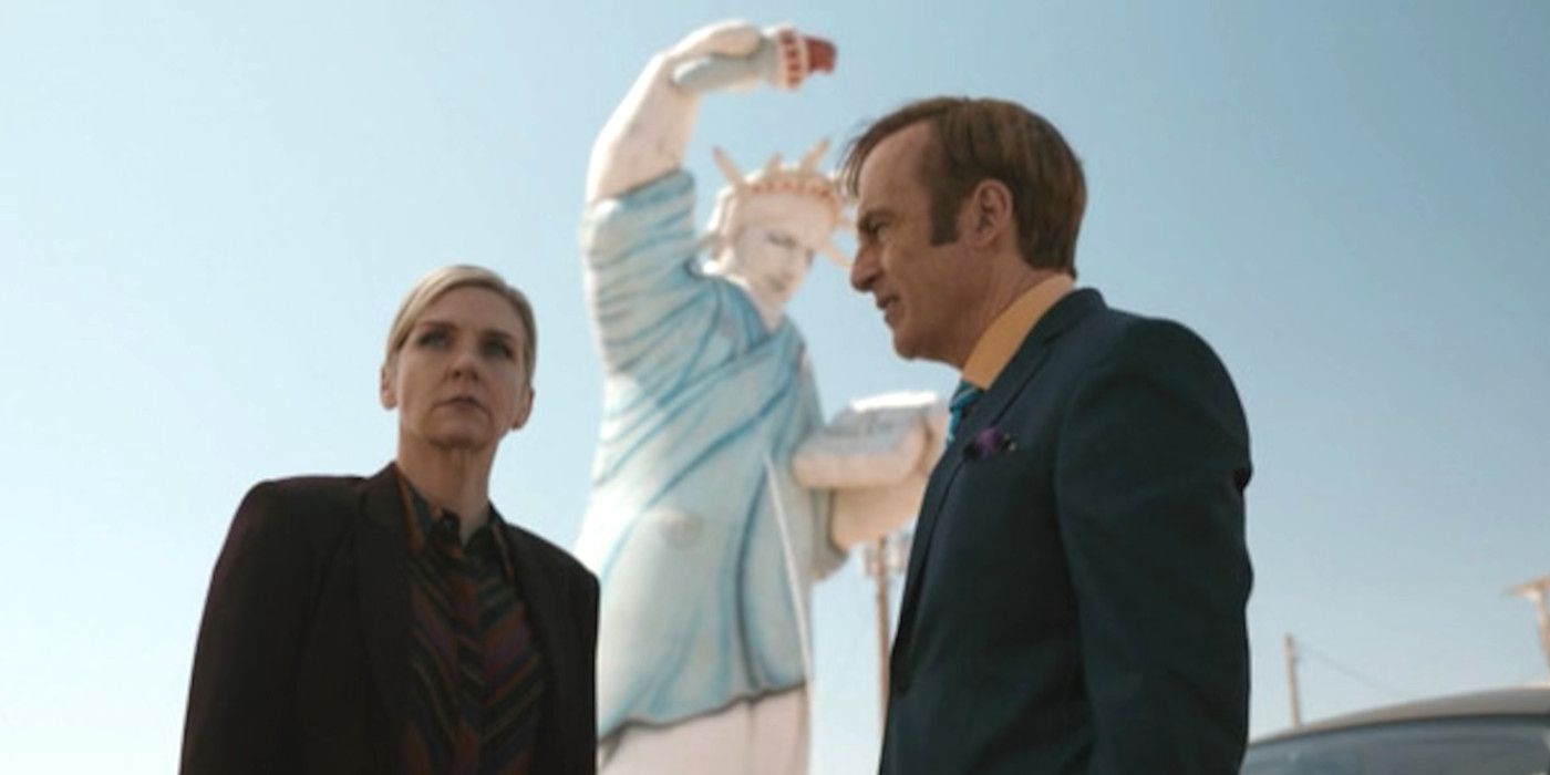 Rhea Seehorn as Kim Wexler and Bob Odenkirk as Jimmy McGill standing in front of an inflatable Statue of Liberty in an episode of Better Call Saul