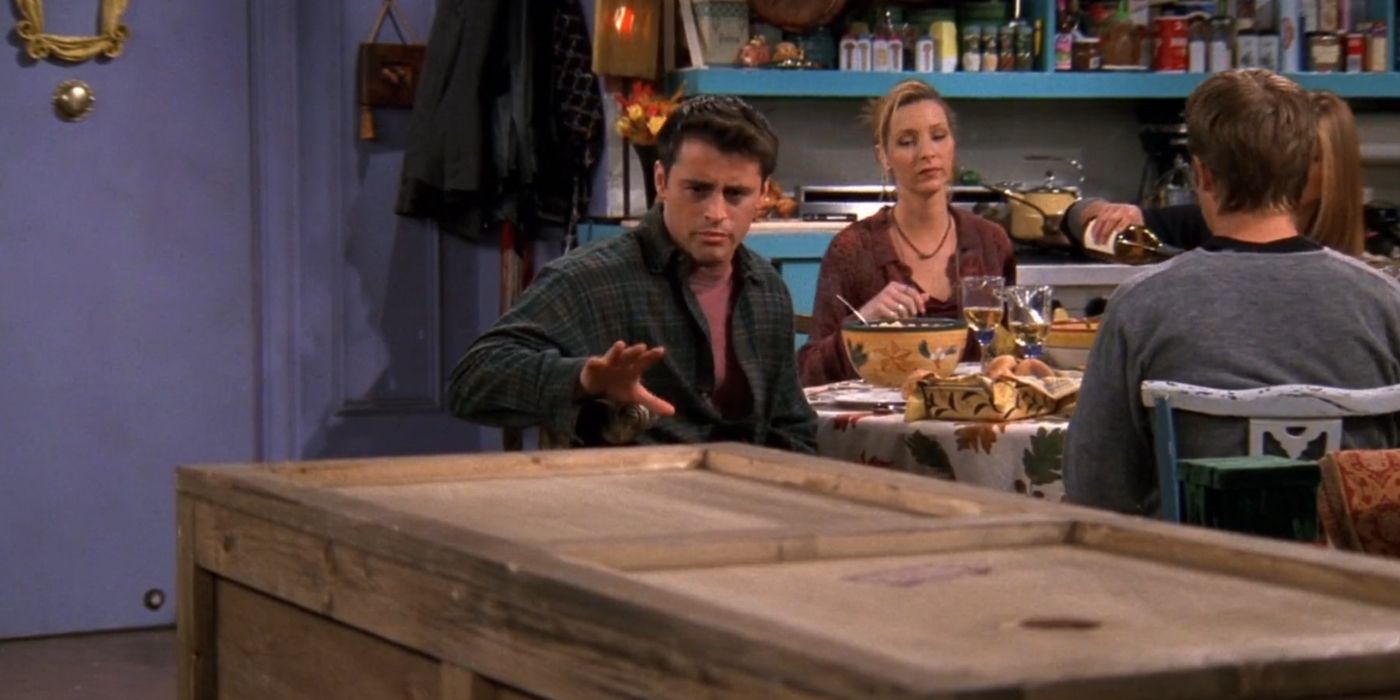 Joey conversando com Chandler que está dentro de uma caixa na Monica's em Friends.