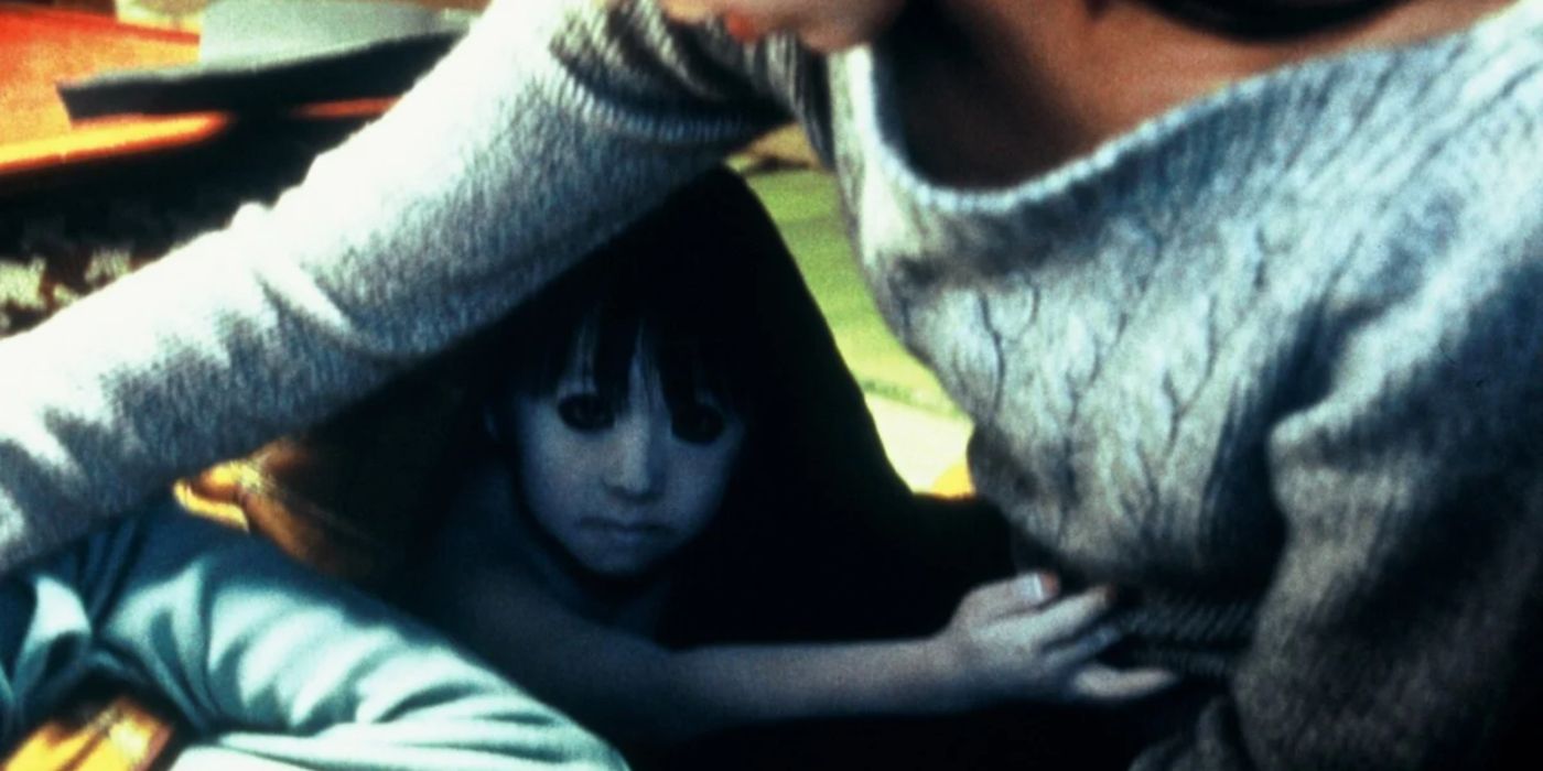 Toshio reaches from under a table in Ju-On- The Grudge