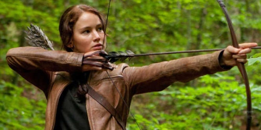 Katniss Everdeen prepara seu arco em Jogos Vorazes 