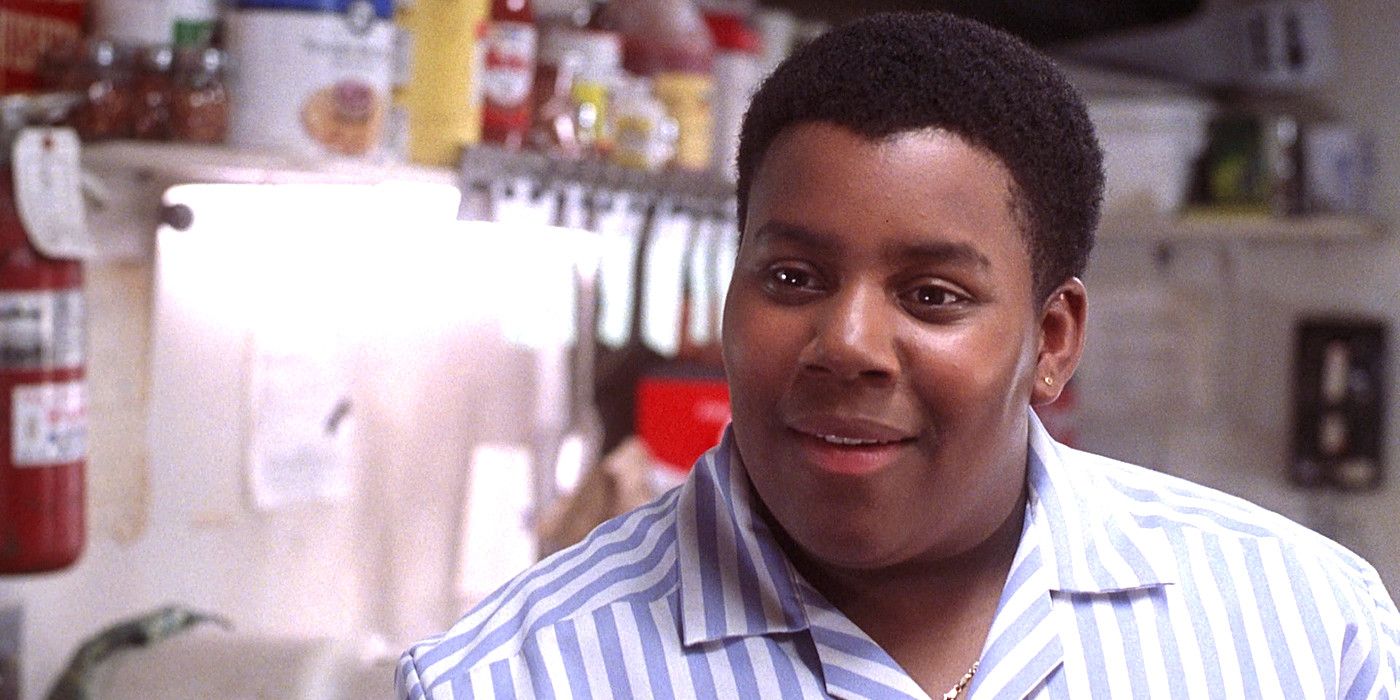 Kenan Thompson in the movie Good Burger wearing a fast food uniform and sitting inside a restaurant having a conversation
