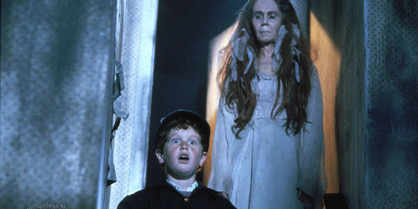 A young boy with a ghost of a woman behind him in Lady In White