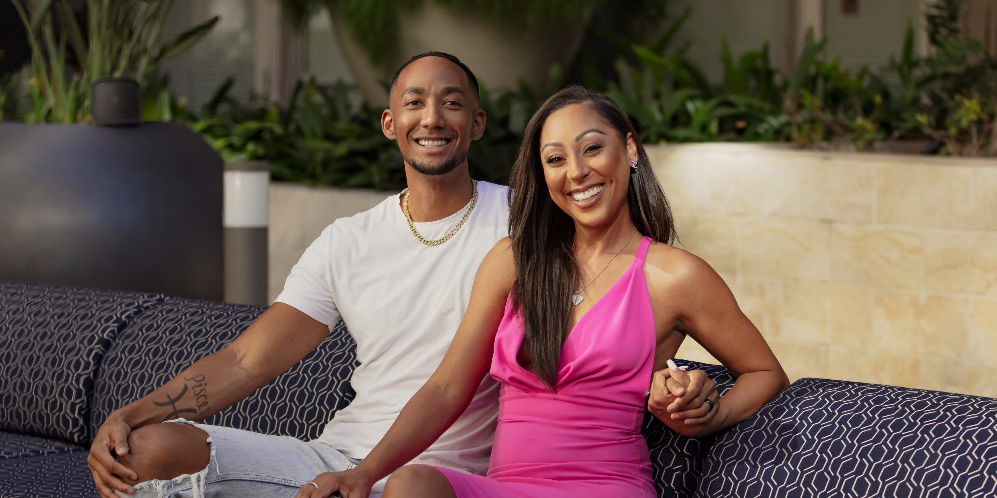 Nate and Stacia sitting on couch and smiling for a photo in Married At First Sight