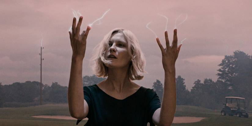 Justine (Kirsten Dunst) looking at electricity running through her fingers in Melancholia