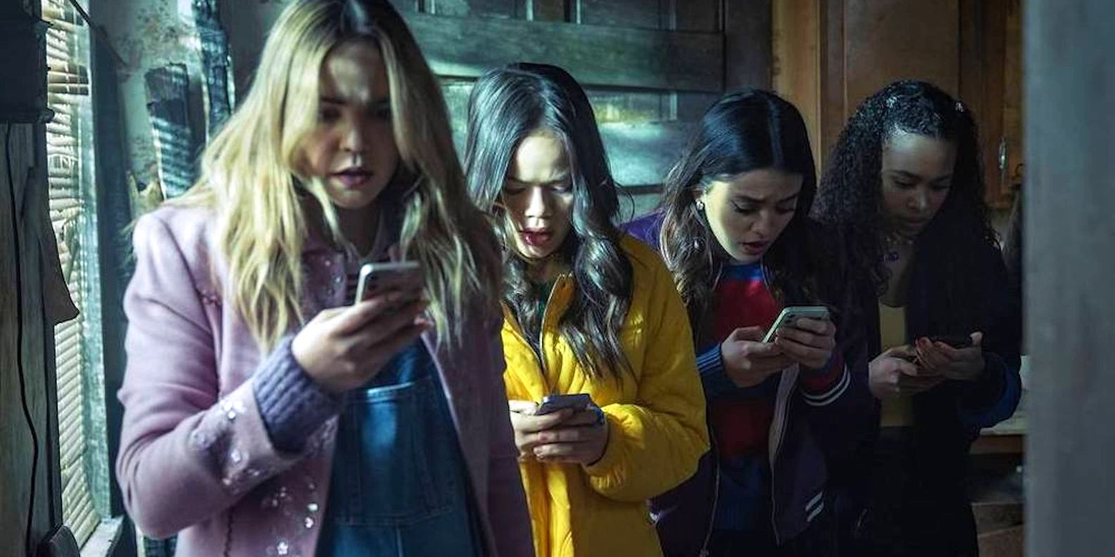 The cast of Pretty Little Liars: Original Sin characters looking at their phones with a terrified expression.