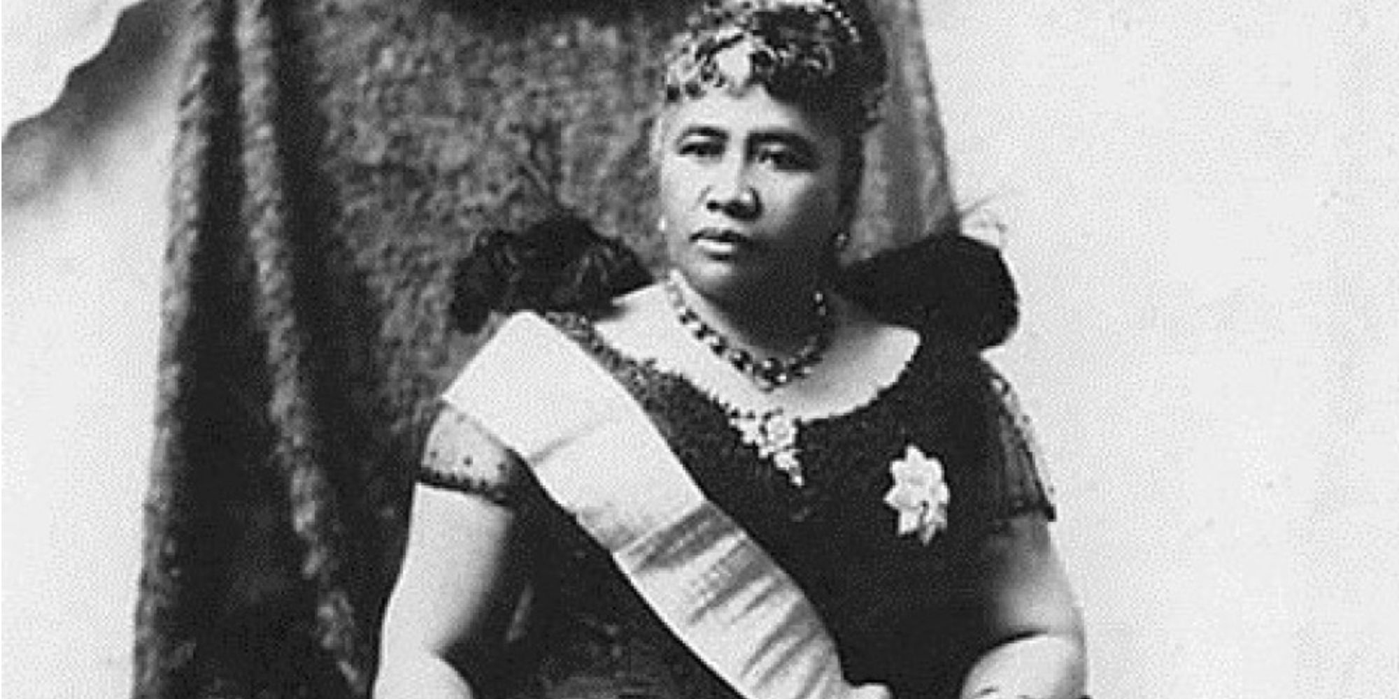 Queen Liliʻuokalani sits upon her throne