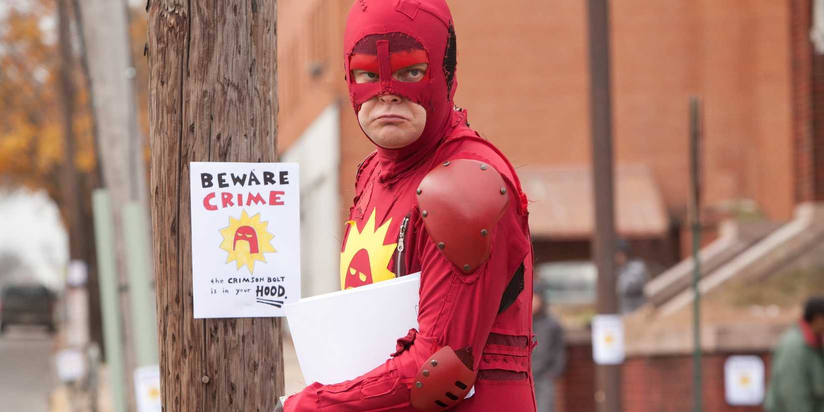 Rainn Wilson as the Crimson Bolt putting up posters in Super