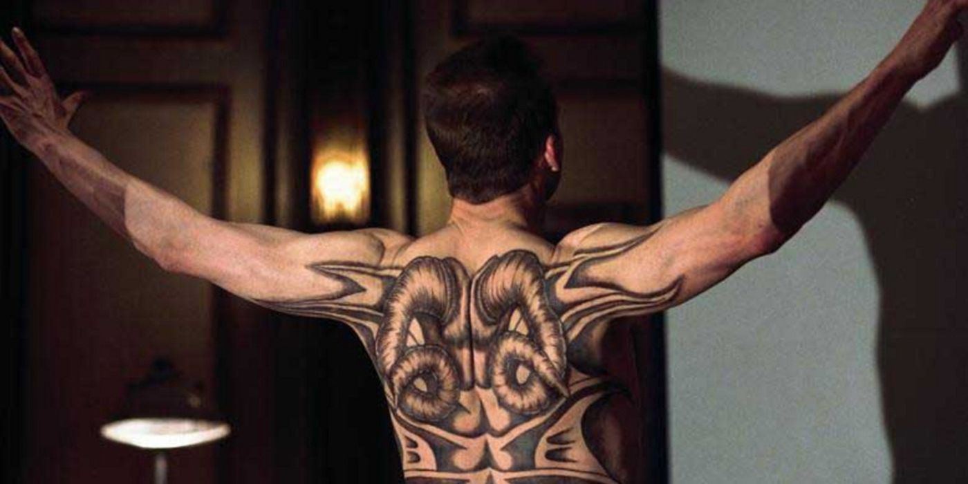 Shirtless Ralph Fiennes Red Dragon standing with arms in air and back to camera