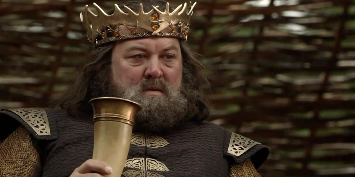 Robert Baratheon drinking wine and wearing a crown in Game of Thrones