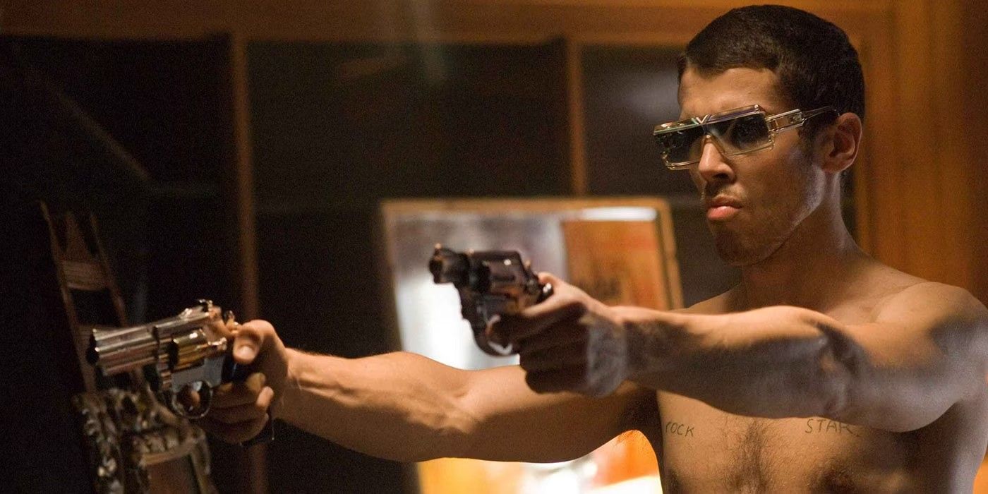 Shirtless man with sunglasses holding two guns in Rocknrolla