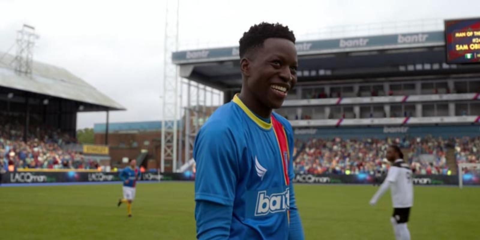 Sam Obisanya smiles in his uniform on the field in Ted Lasso