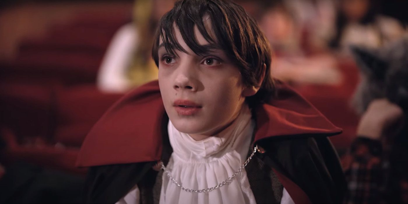A kid is dressed up as Dracula in a movie theater