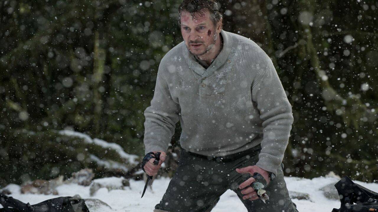 Liam Neeson segurando uma faca na neve em The Grey