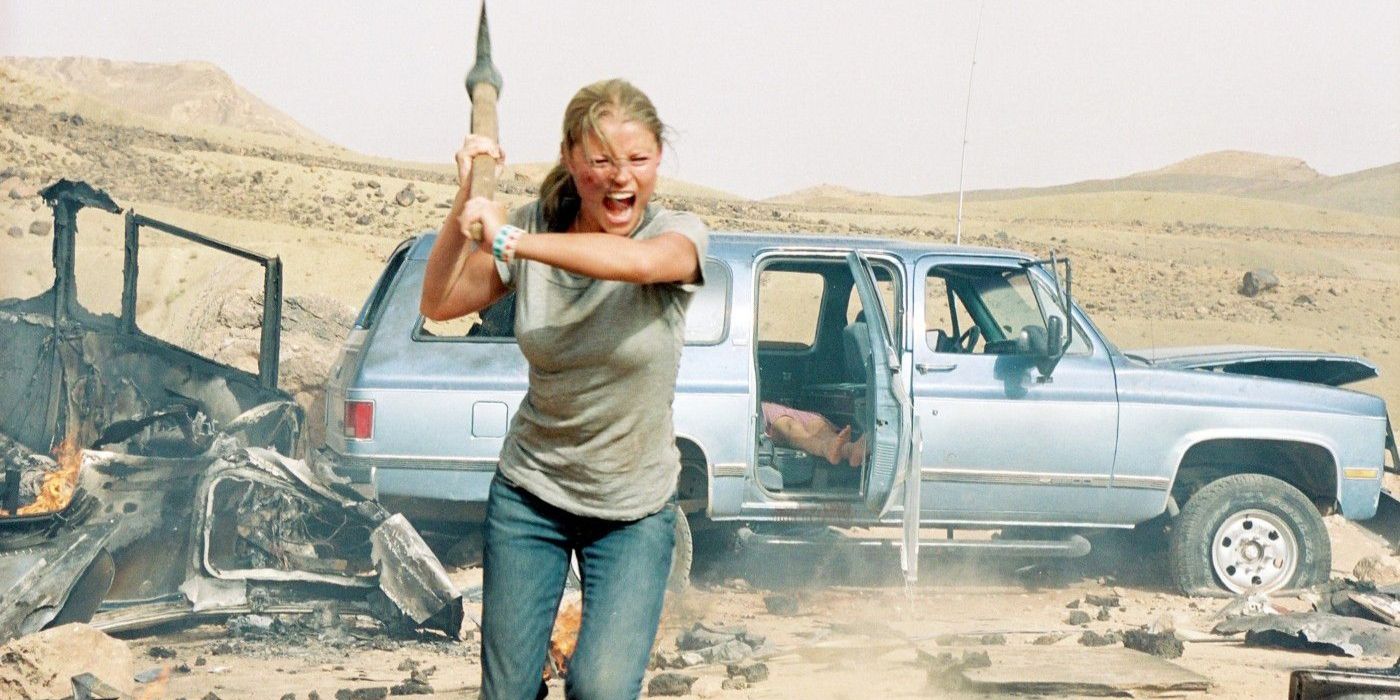 Lynn Carter-Bukowski holding up a weapon in front of a car in The Hills Have Eyes (2006)