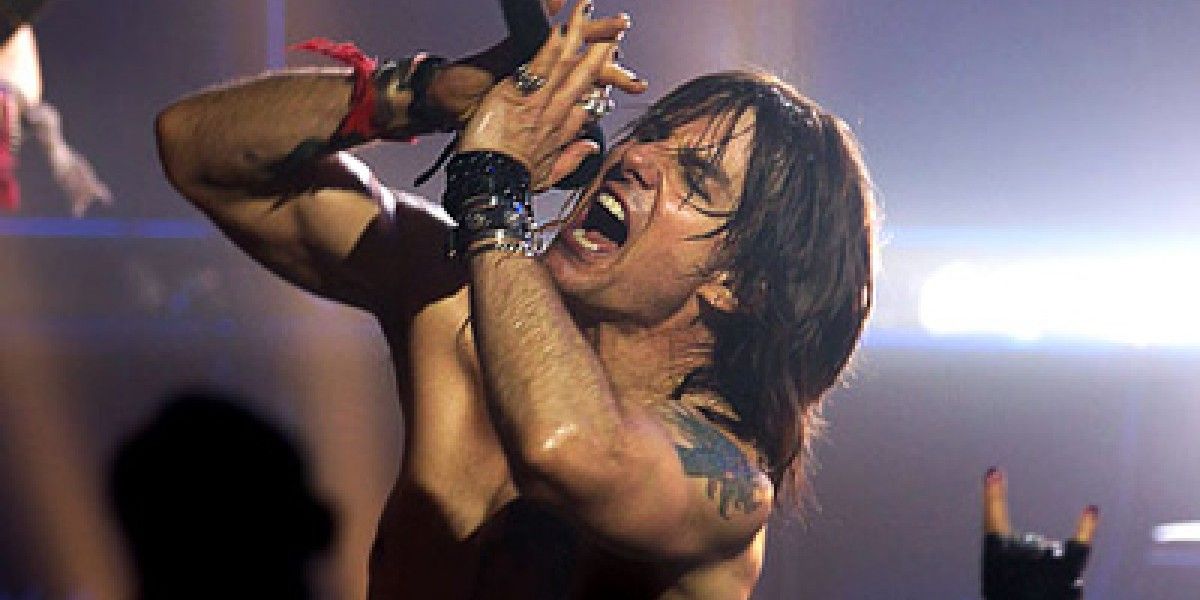 Tom Cruise cantando sem camisa no palco em Rock of Ages