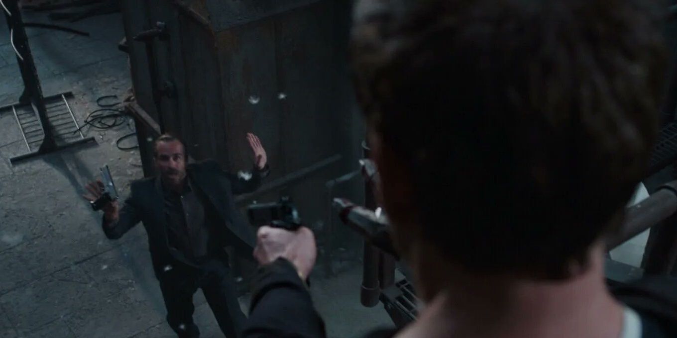 Tony segura um capanga sob a mira de uma arma em Homem de Ferro 3