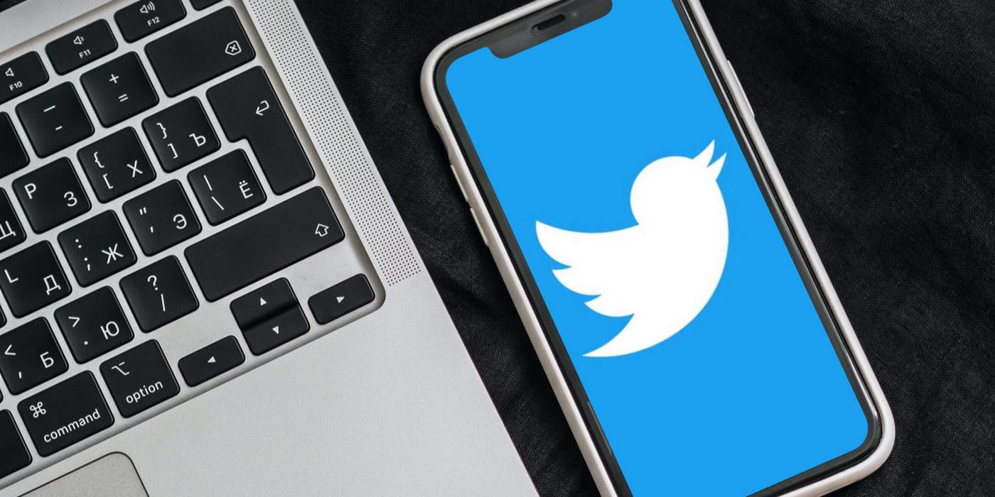The iPhone 11 Twitter logo is shown next to a partial view of a MacBook keyboard