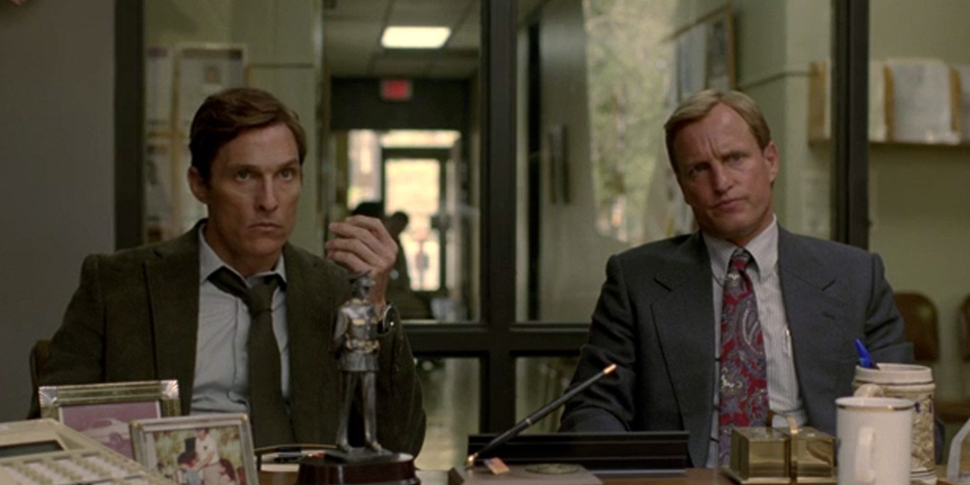 Dois detetives sentados em uma mesa em True Detective 