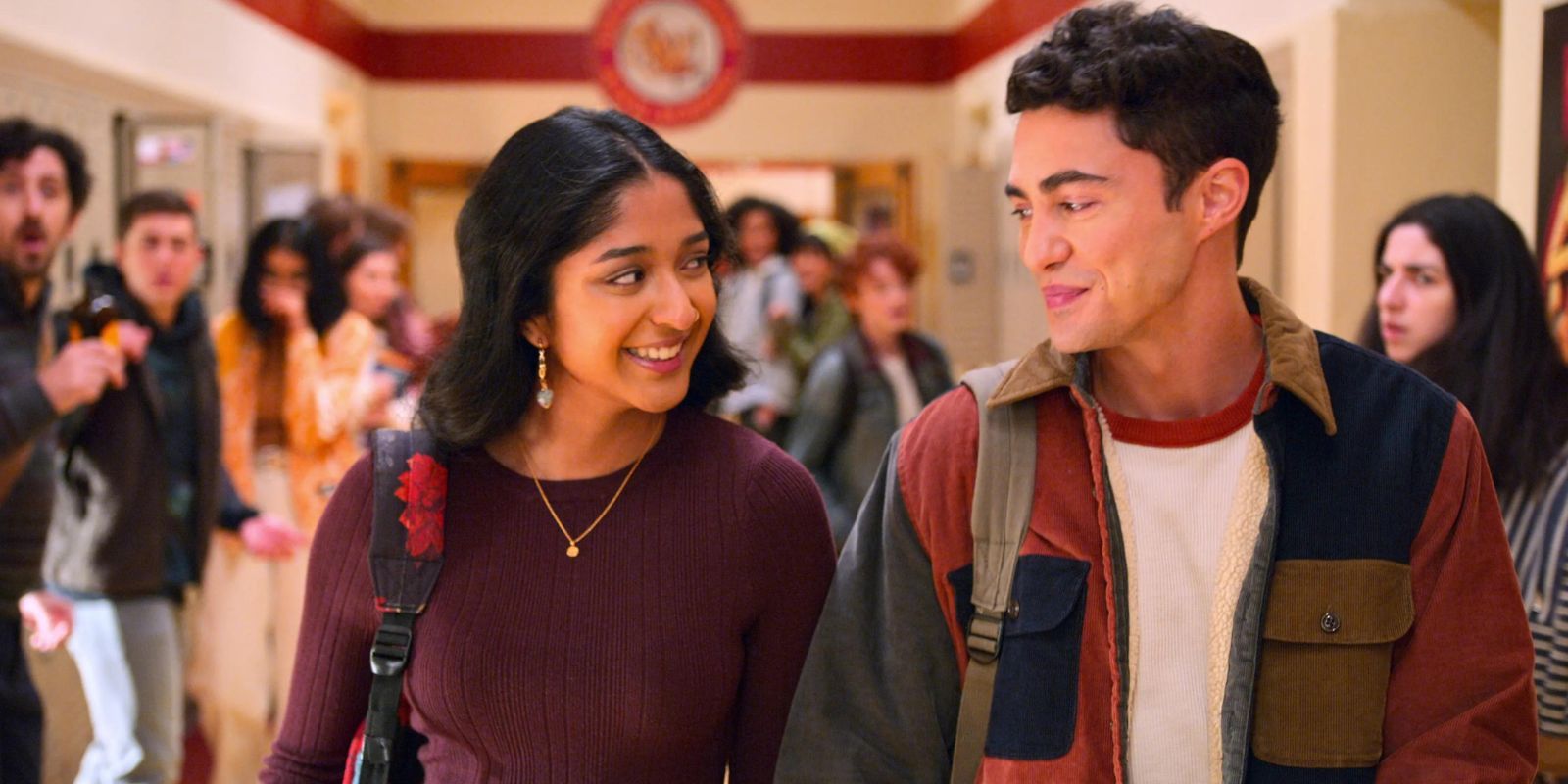 Devi and Paxton smiling while walking down the school hallway