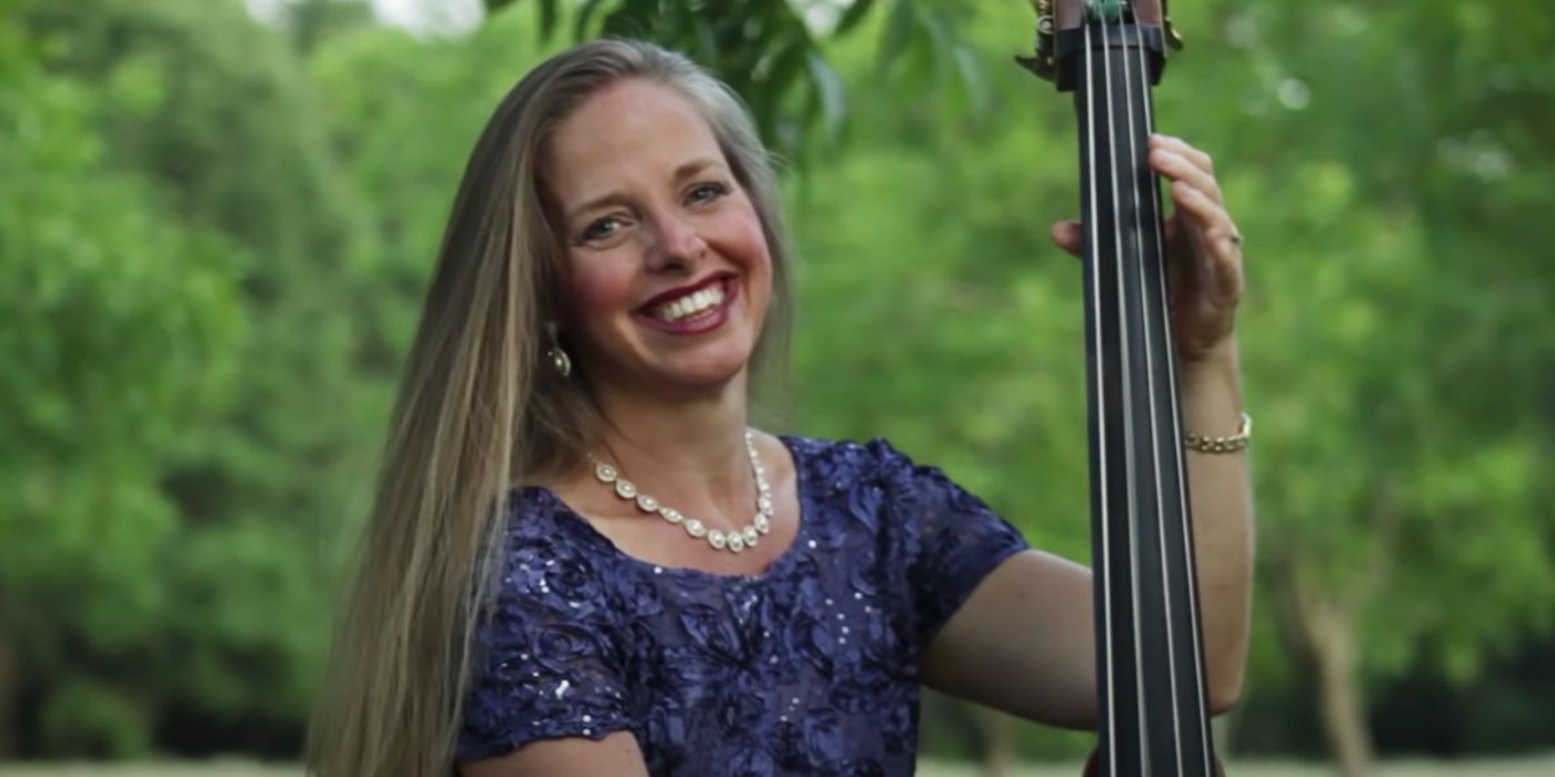 Welcome to Plathville's Kim Plath smiling holding a cello