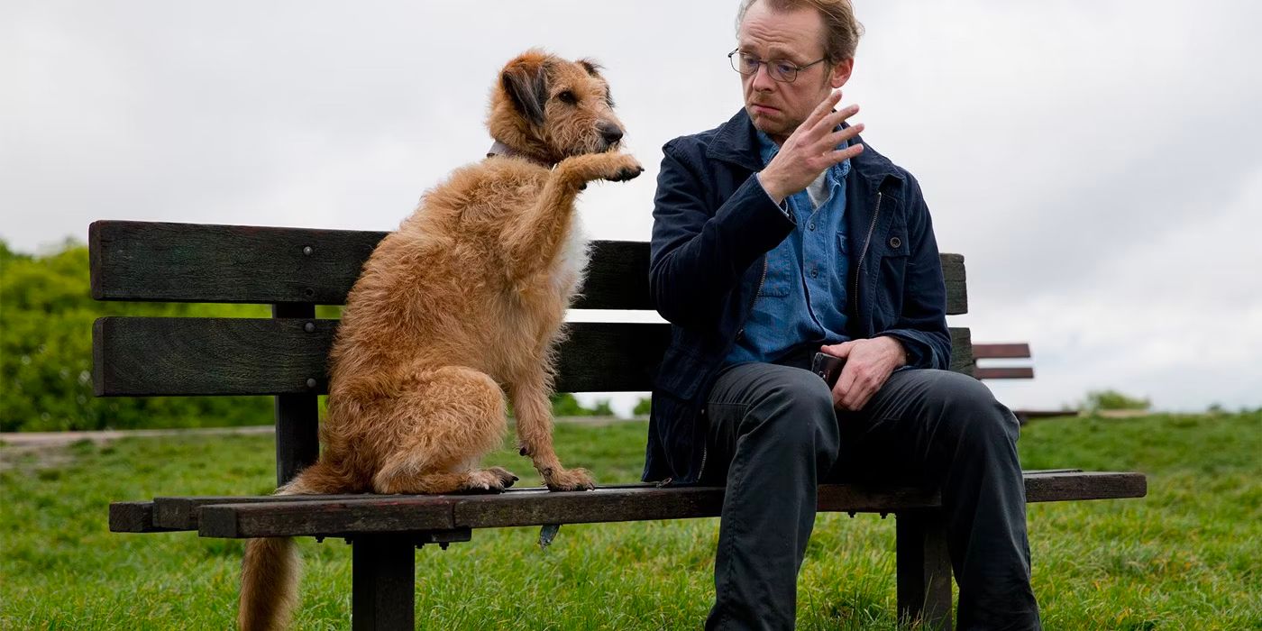 simon pegg and a dog on a bench in absolutely anything