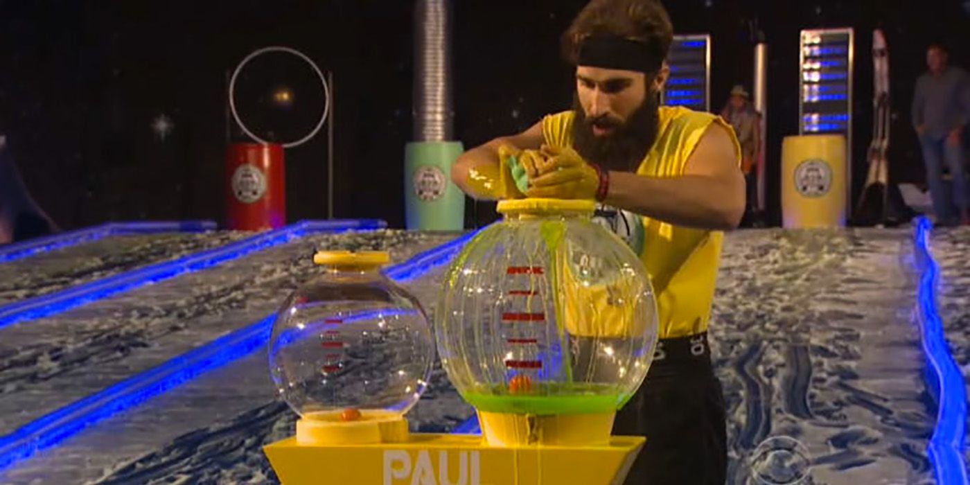 Paul jogando água em uma tigela grande durante a competição Slippery Slope no Big Brother.