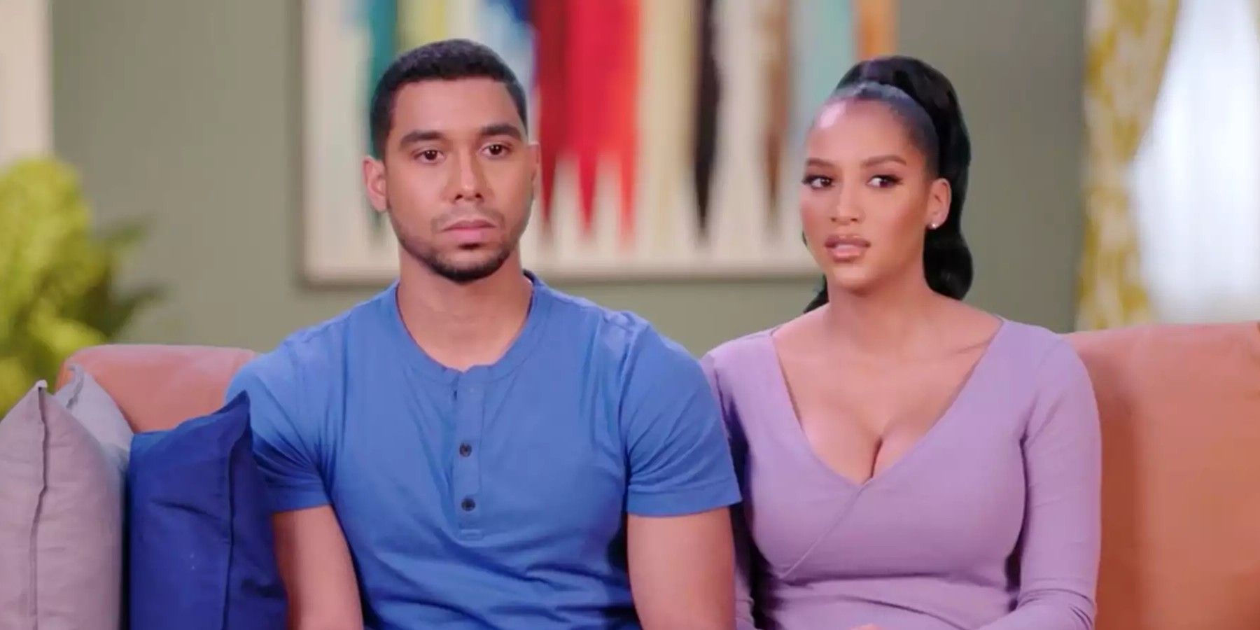 Chantel Everett and Pedro Jimeno sitting on couch looking serious