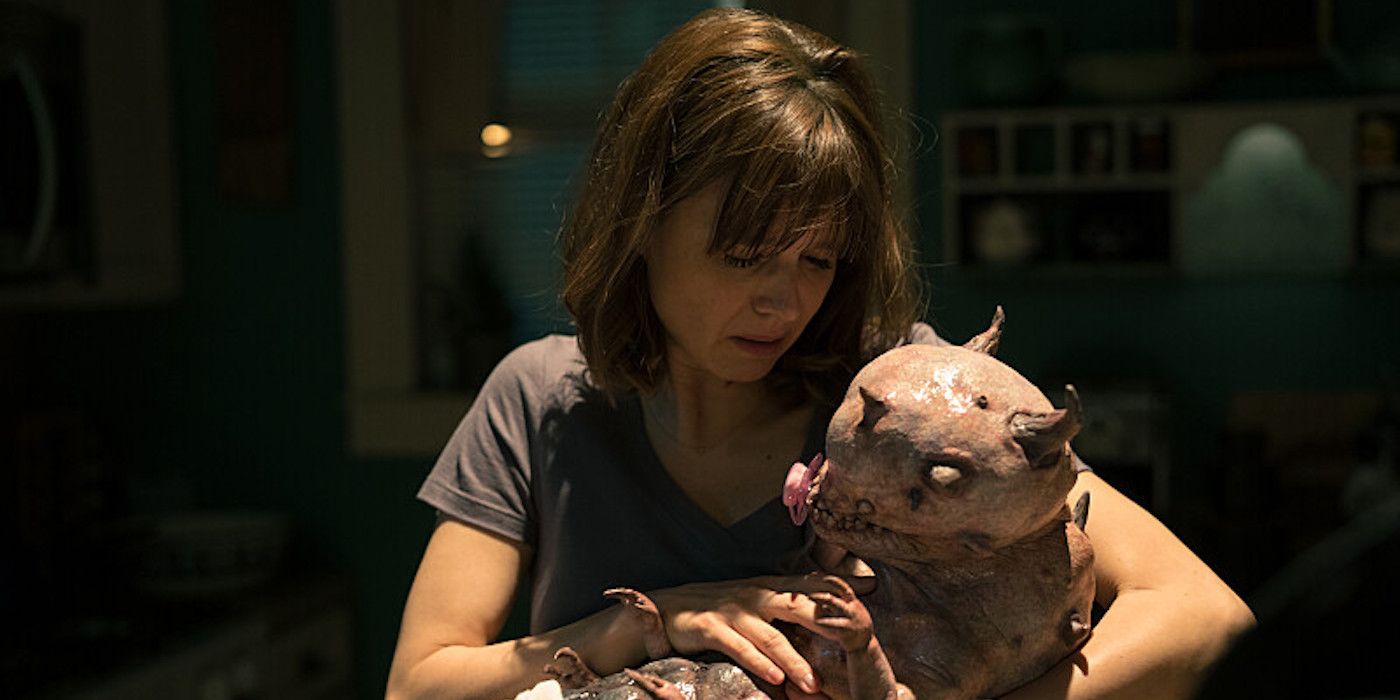 Kristen (Katja Herbers) segurando um bebê demônio desajeitadamente em seus braços em Evil