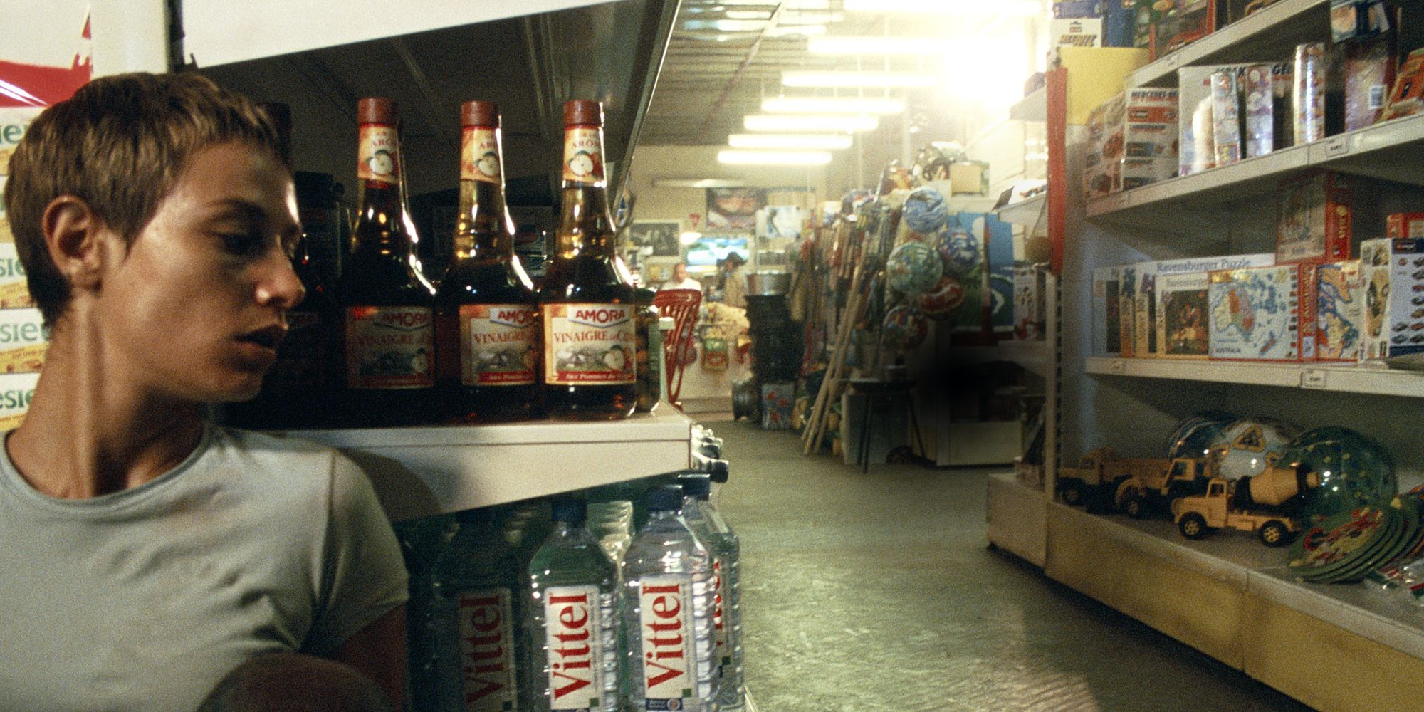 A girl hiding behind a shelf in a store in High Tension