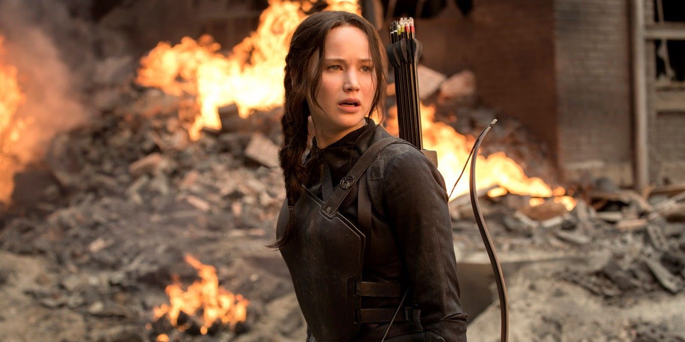 Katniss looking up while standing among fiery rubble in Mockingjay.