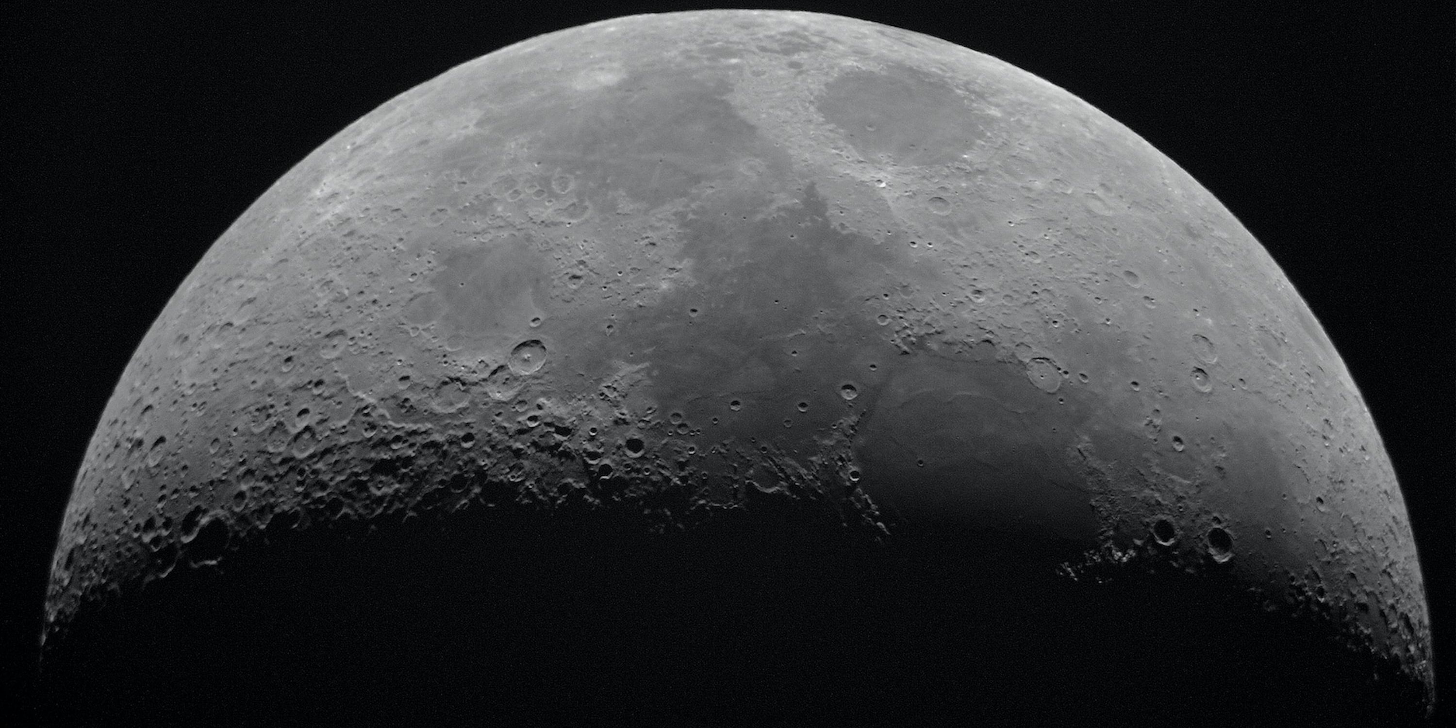 Half the moon against black sky.