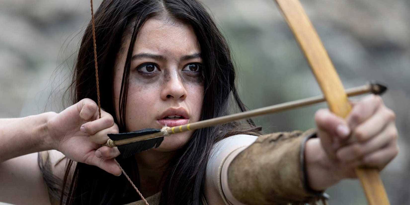Amber Midthunder as Naru with an arrow nocked in her bow in Prey