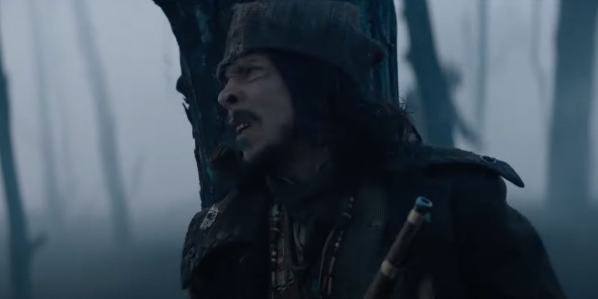 fur trapper hides behind a tree as a predator hunts his companions