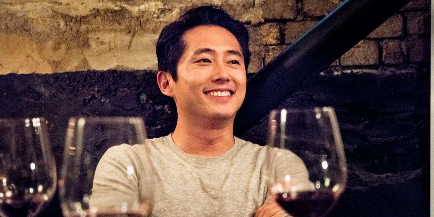 steven yeun with wine glasses burning