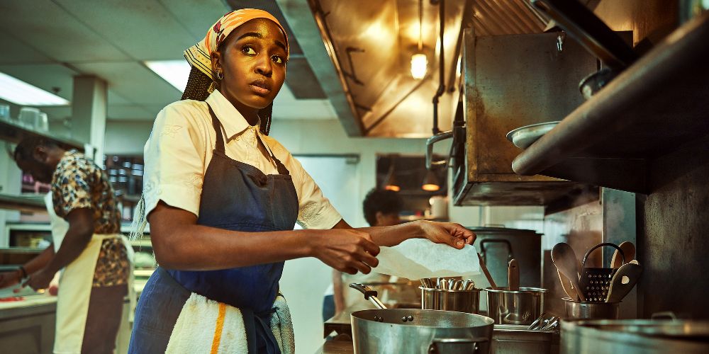 Sydney fica ao lado de uma panela na cozinha no The Bear