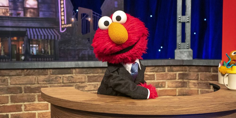Elmo sits at his desk in The Not-Too Late Show With Elmo