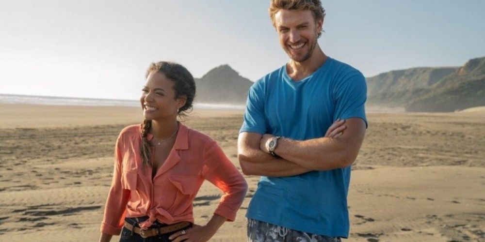 A man and woman laughing at the beach in Falling Inn Love