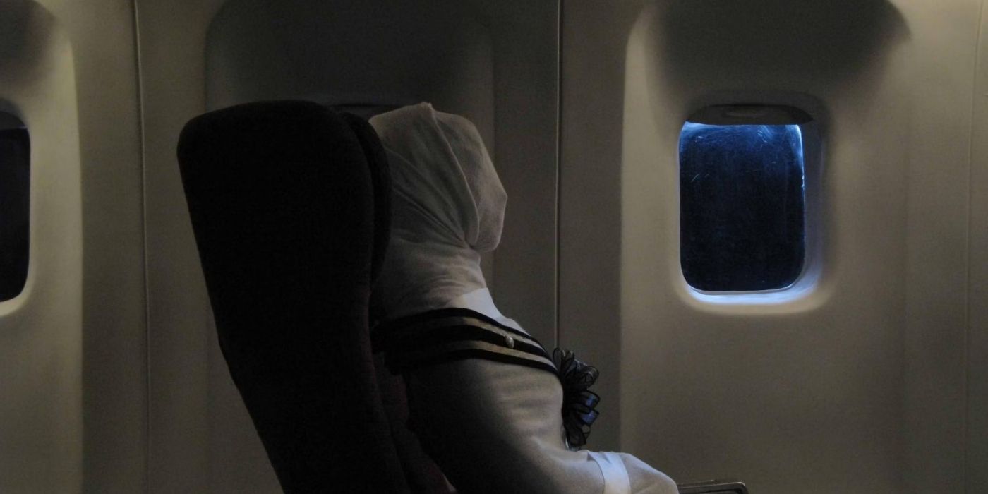 A scene from 4bia, a wrapped up dead body on a plane