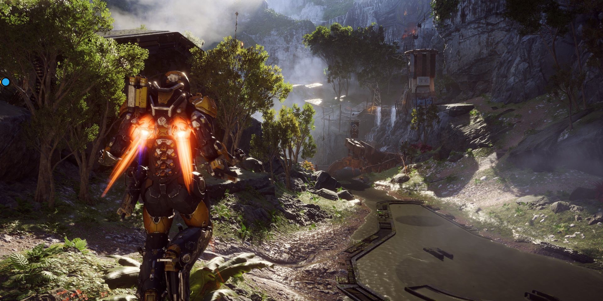 A screenshot from BioWare's Anthem, showing a person in a suit of mechanical armor hovering over the bank of a small river surrounded by forest.