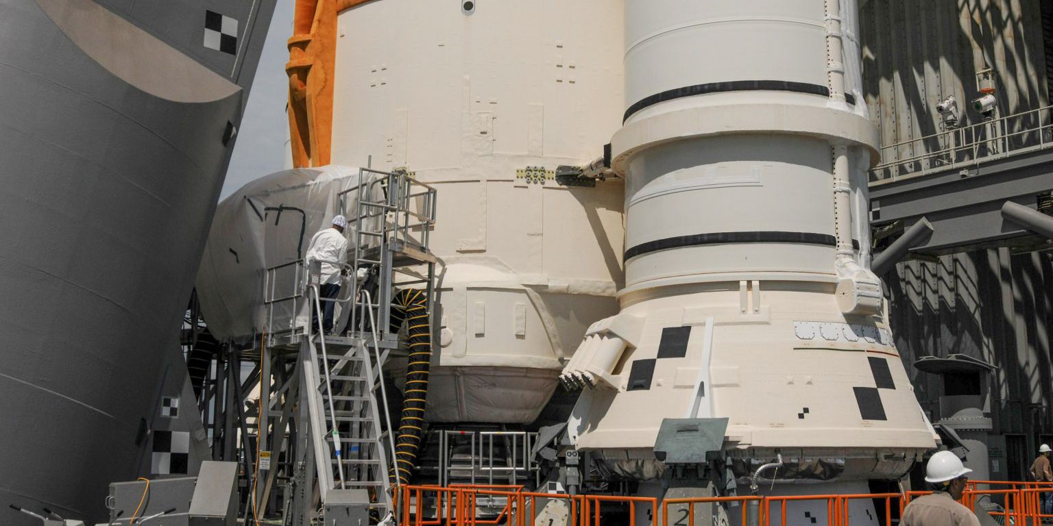 The base of the SLS rocket on the launch pad with repair crews at work.