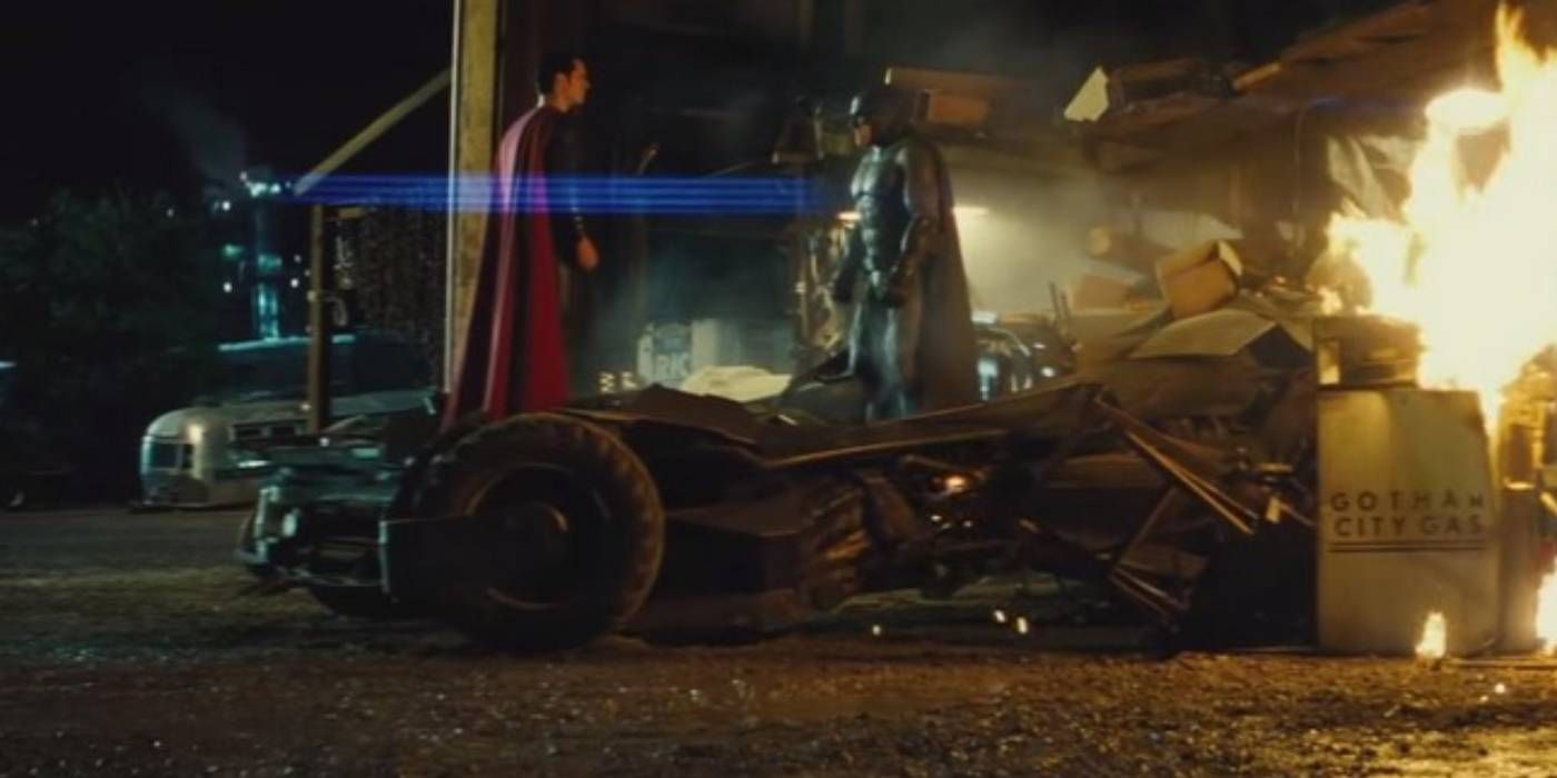 Batman and Superman face each other by the crashed batmobile in Batman v Superman
