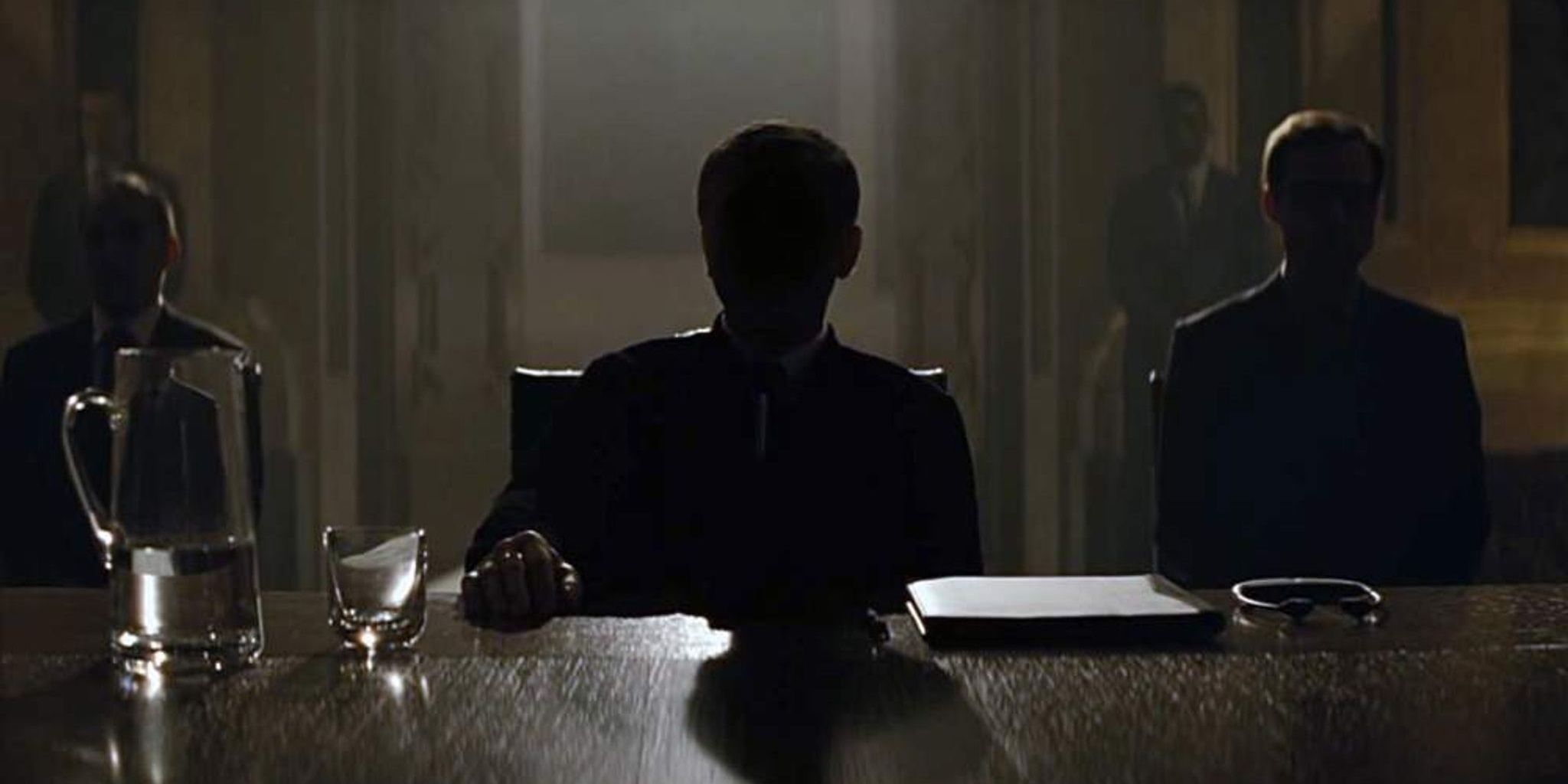 Blofeld sitting at the head of a table in Spectre