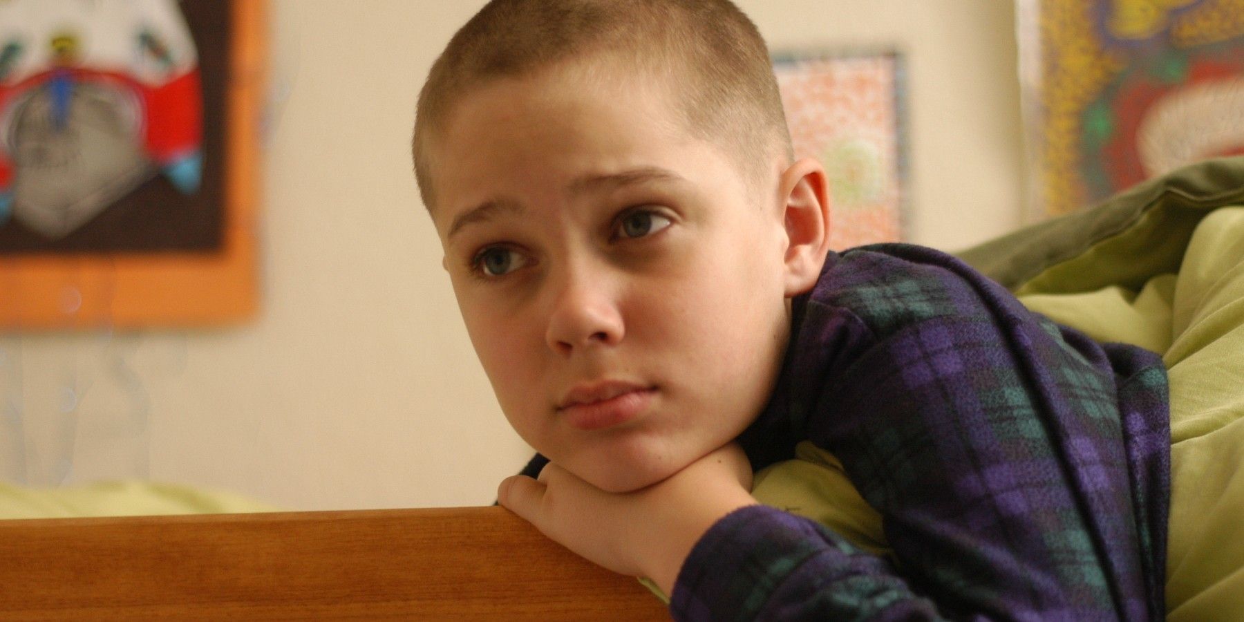 Ellar Coltrane as Mason Evans Jr. in Boyhood with a shaved head, leaning out of his bed 